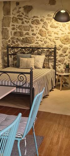 a bedroom with a bed and a blue chair at St Thomas House in Adhráktia