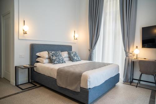 a bedroom with a large bed with blue pillows at Monteroduni 22 - Chiaia Design Rooms in Naples