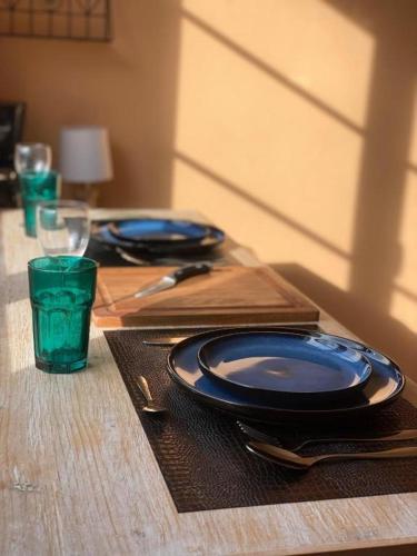 une table en bois avec deux plaques bleues et un verre dans l'établissement Petit appartement au centre de Concarneau, à Concarneau
