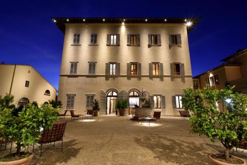a large building with chairs in front of it at Villa Sabolini in Colle Val D'Elsa