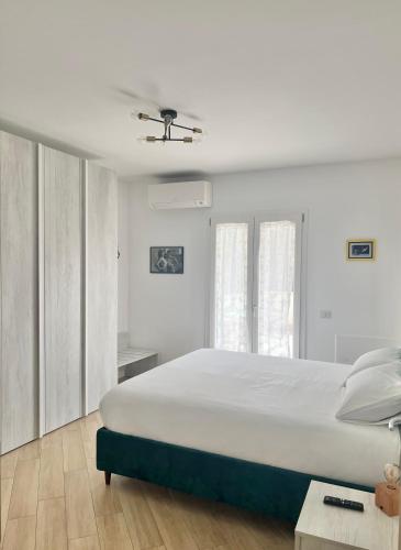 a white bedroom with a large bed and a ceiling at Casa Vacanze Tellus in Ciampino
