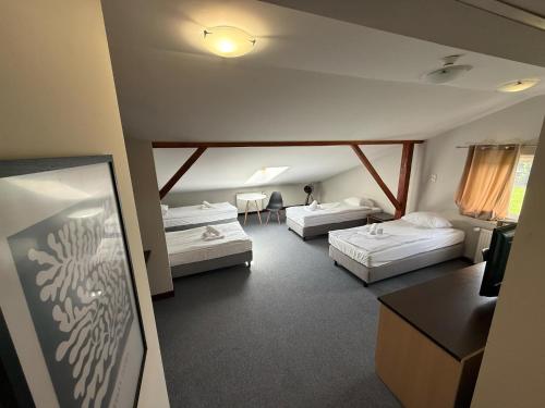 a hotel room with two beds and a table at Mąka i Magia - Kuchnia regionalna - Agroturystyka in Zambrów
