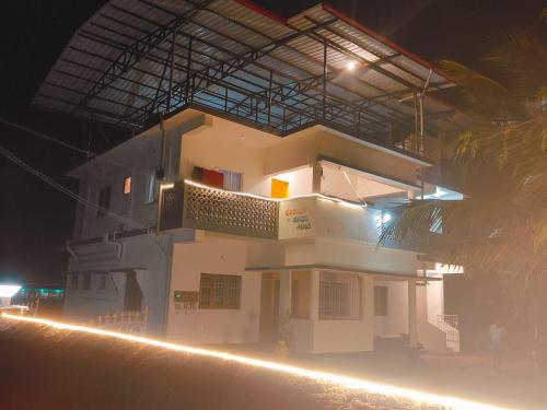 a large white building with a balcony at night at Nature Beach Stay in Gokarn