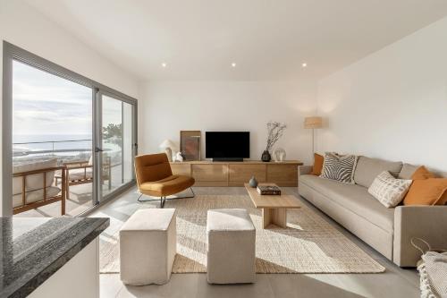 a living room with a couch and a tv at Casa LukStian in Nazaré
