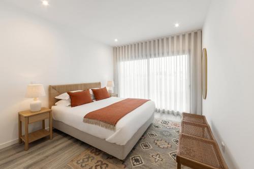 una camera da letto con un letto grande e una finestra di Casa LukStian a Nazaré
