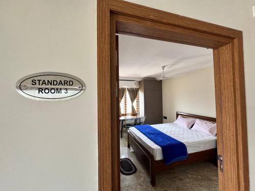 a bedroom with a bed and a sign that reads standard room at hOTEL MADHAVA RESIDENCY in Kākināda