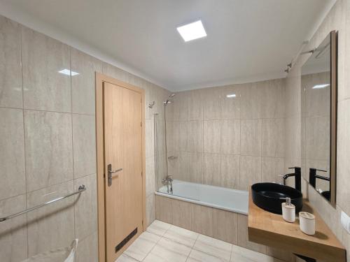 a bathroom with a tub and a toilet and a sink at RenTenerife Magec Swing & Sun Amarilla Golf in San Miguel de Abona