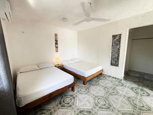 1 Schlafzimmer mit 2 Betten und Teppichboden in der Unterkunft Centrally located apartment 2 blocks from the sea in Cozumel