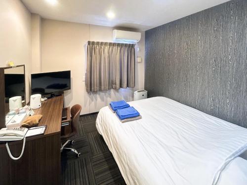 a hotel room with a bed and a desk and a television at Business Hotel Goi Onsen - Vacation STAY 78235v in Ichihara