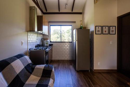 a kitchen with a refrigerator and a sink at Villaggio dos Pássaros in Paranoá