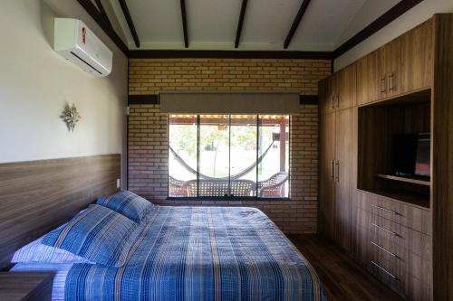 a bedroom with a bed and a window in it at Villaggio dos Pássaros in Paranoá