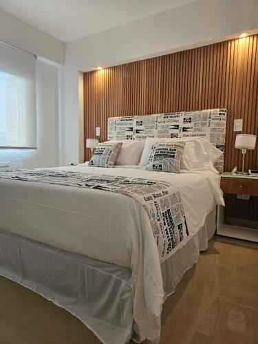 a bedroom with a large white bed with pillows at Departamento 12 Tower in Salta