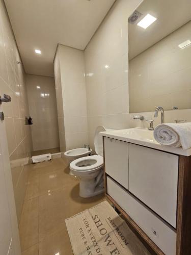 a bathroom with a toilet and a sink and a mirror at Departamento 12 Tower in Salta