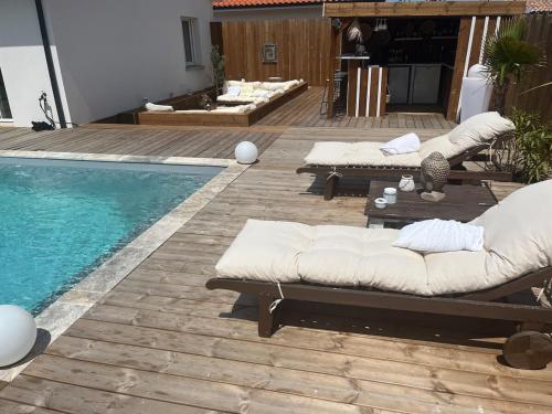 - une piscine avec chaises longues et chaises à côté de la piscine dans l'établissement Villa Zerua & Spa, à Mimizan