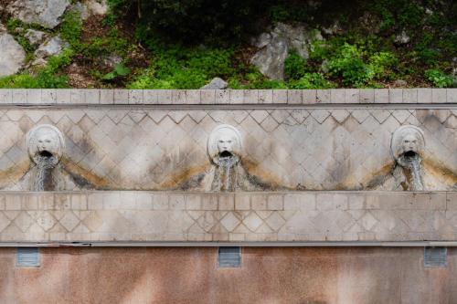 a fountain with two faces on a wall at Domus Polymnia, hospitality at its best! in Spílion