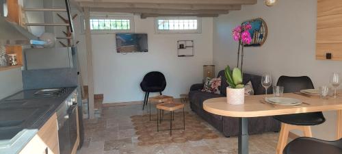 une cuisine et un salon avec une table et un canapé dans l'établissement Appartement cosy, à Cabrières