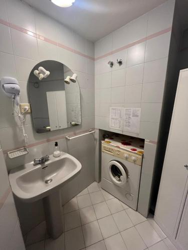 a bathroom with a sink and a washing machine at Estudio junto al mar in Torrox Costa