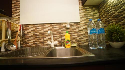 a kitchen sink with two bottles of detergent and water at Service Apartment by World Inn in Karachi