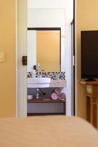 a bathroom with a sink and a mirror at Villaggio dos Pássaros in Paranoá