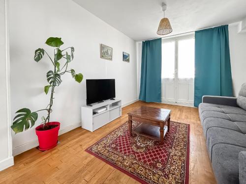 un salon avec un canapé et une télévision dans l'établissement Appartement Lumineux, Proche Centre Dijon, à Dijon