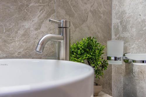 a bathroom with a sink and a faucet at Del Mar Sithonia Studios&Apartments in Neos Marmaras
