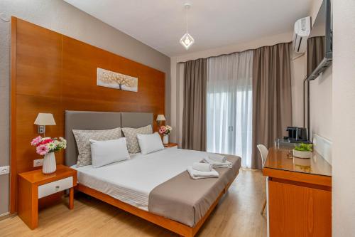 a bedroom with a large bed with a wooden headboard at Del Mar Sithonia Studios&Apartments in Neos Marmaras
