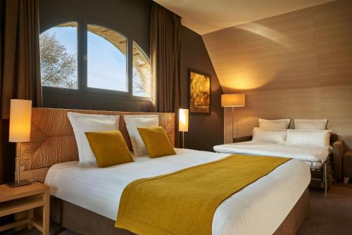 une chambre d'hôtel avec deux lits et une fenêtre dans l'établissement Château De Villiers-Le-Mahieu, à Villiers-le-Mahieu