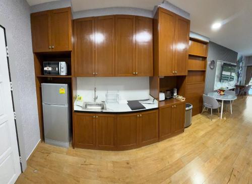 a kitchen with wooden cabinets and a table in a room at Pattaya Beach View Talay 6 by AEGEAN Suite Condo in Pattaya Central