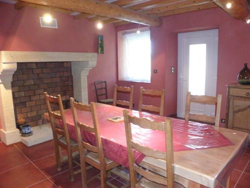 une salle à manger avec une table et une cheminée dans l'établissement Les bananiers, à Sauveterre
