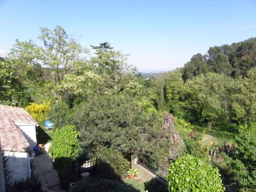 Elle offre une vue sur une cour arborée et une maison. dans l'établissement Les bananiers, à Sauveterre
