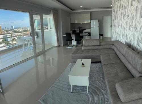 a living room with a large couch and a table at Pattaya Beach View Talay 6 by AEGEAN Suite Condo in Pattaya Central