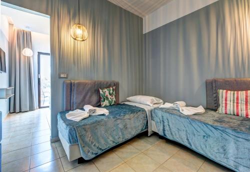 two beds in a hotel room with towels on them at Lindos Breeze Beach Hotel in Kiotari