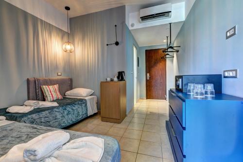 a hotel room with two beds and a television at Lindos Breeze Beach Hotel in Kiotari