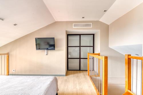 a bedroom with a bed and a tv on the wall at Hotel Villa d'Elsa in Juan-les-Pins