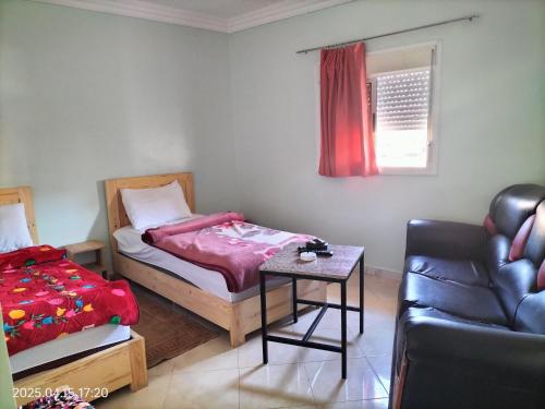 a bedroom with a bed and a table and a couch at HOTEL 7DAYS DAkHLA in Oulad Akkou