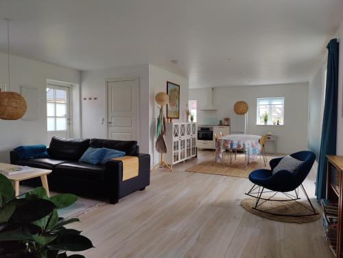 a living room with a black couch and a table at GIMLEretreat in Marielyst