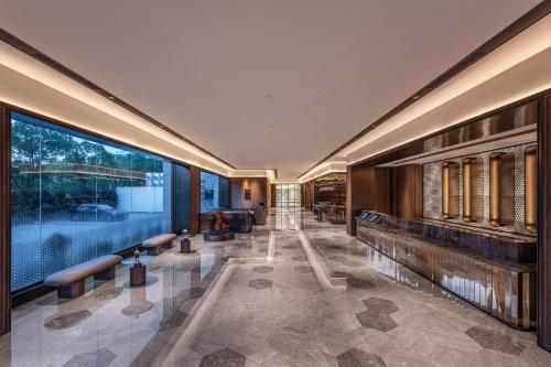 a lobby with benches and a large window at Orange Crystal Hotel Zhizhu Garden East China Normal University Minhang District Shanghai in Shanghai