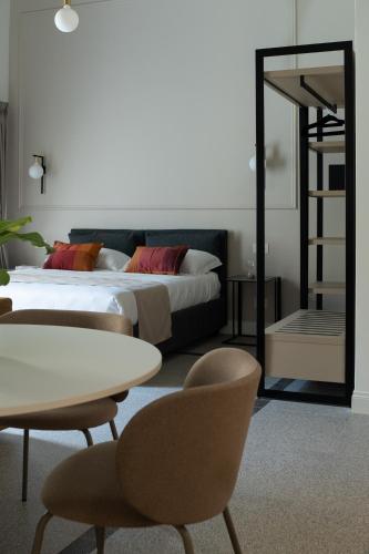 a bedroom with a bed and a table and chairs at Monteroduni 22 - Chiaia Design Rooms in Naples