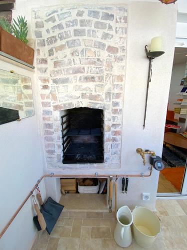 une cheminée dans une pièce avec un mur en pierre dans l'établissement Calme absolu et terrasse à Bastille, à Paris