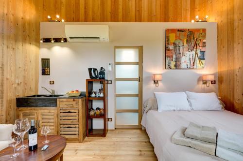 - une chambre avec un lit et une table avec des verres à vin dans l'établissement Coup 2 Foudres, à Saint-Jean-de-Blaignac