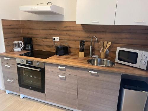 eine Küche mit Spüle und Mikrowelle in der Unterkunft Modernes Wohnerlebnis in bester Lage in Heilbronn