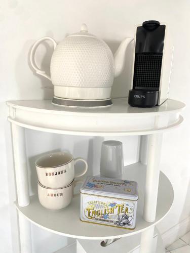 a white shelf with a tea pot and a laptop at Maison Galop Marin in Saint-Côme-du-Mont