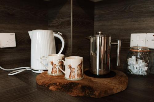 a couple of coffee mugs on a wooden cutting board at 15 Queen Elizabeth Way, Kirkwall in Orkney