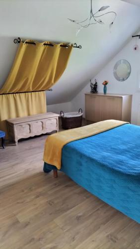 sypialnia z łóżkiem z niebieskim kocem w obiekcie Appartement Vallée de la Risle w mieście Glos-sur-Risle
