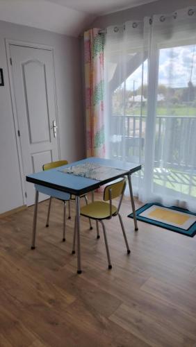 une table et des chaises dans une pièce avec une fenêtre dans l'établissement Appartement Vallée de la Risle, à Glos-sur-Risle
