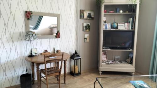 salon ze stołem i lustrem w obiekcie Appartement Vallée de la Risle w mieście Glos-sur-Risle