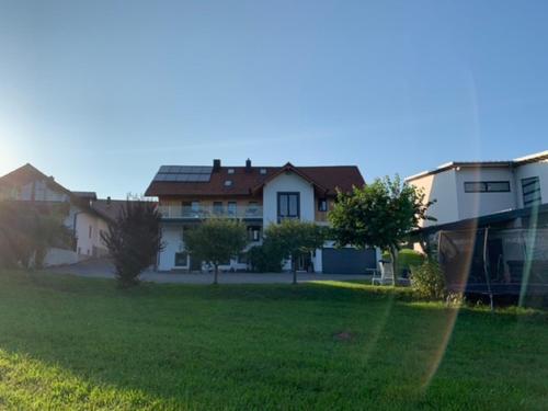 a group of houses in a yard with a green field at Ferienwohnung BEER in Mauth