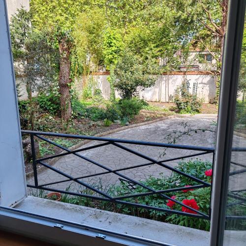 a view of a garden from a window at Haven Douce in Champigny-sur-Marne