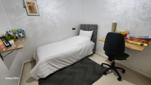 a bedroom with a bed and a desk and a chair at Appartement C à 7 min de l’aéroport de Marrakech in Marrakech