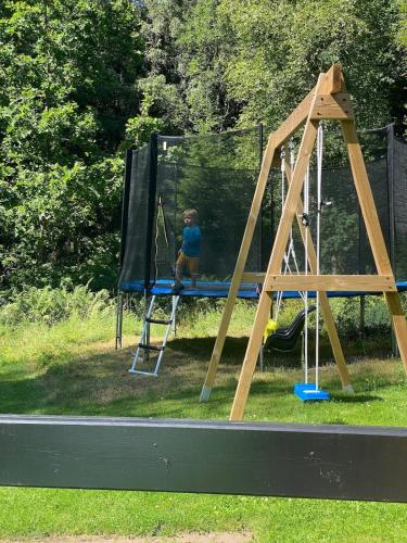 a young child playing on a swing set at Blockhütte in Alleinlage in Ulricehamn